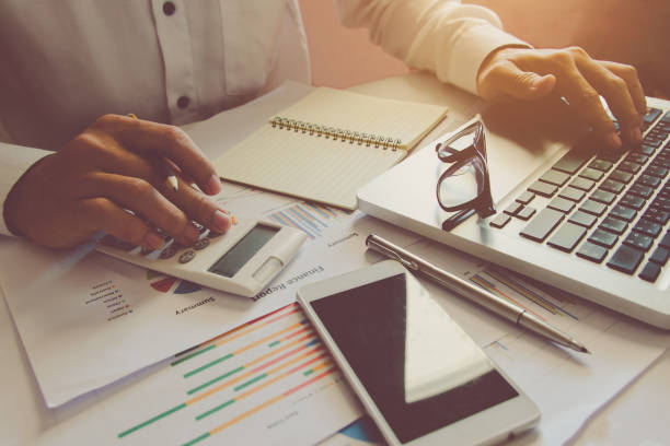 istock Man hand using a financial calculator with touch on laptop touch pad and Financial data analyzing on desk at home 912460636