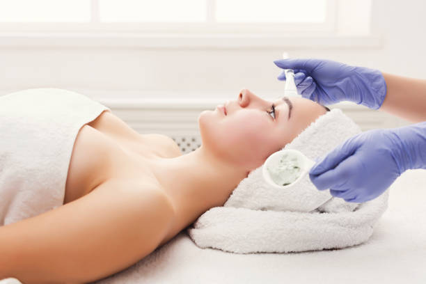 istock Woman gets face mask by beautician at spa 912466518