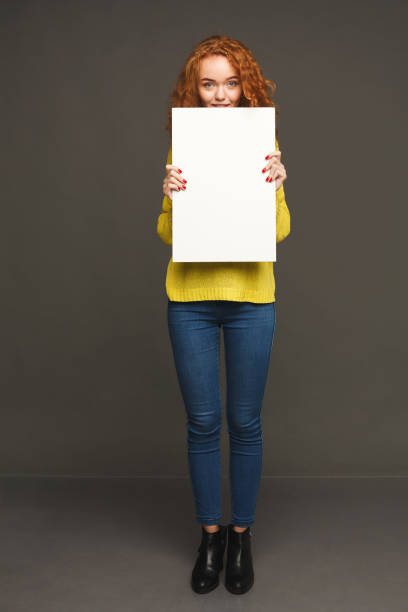 young happy woman with blank white paper - placard women holding standing imagens e fotografias de stock