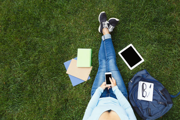 istock Girl with smartphone on the grass 912479050