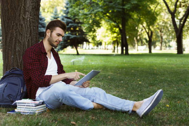 istock Concentrated student preparing for exam in park 912481692