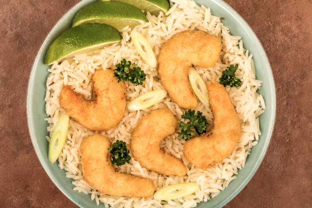 Bowl of Japanese Style Deep Fried Prawn Tempura And Boiled Rice With Slices Of Lime