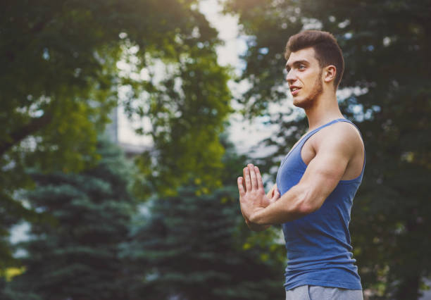 istock Meditating man with praying hands outdoors 912492964