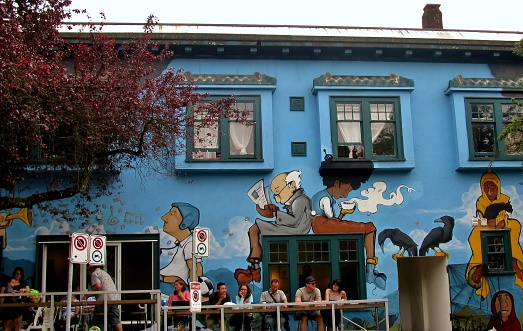 Vancouver, BC, Canada -  12 June, 2016: People at Renzo's sidewalk cafe relaxing over beverages under painted mural.