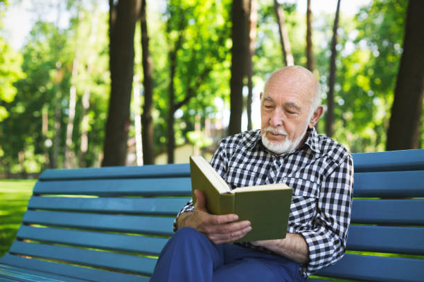 istock Elderly man in casual reading outdoors 912498620