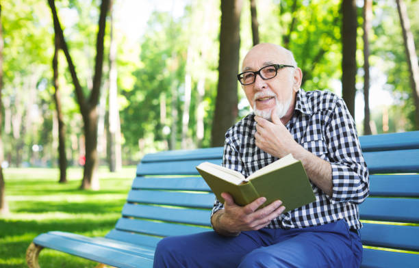 istock Elderly man in casual reading outdoors 912498668
