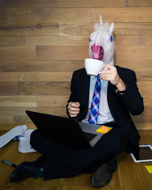 istock Unicorn in a suit and tie drinks coffee 912501152