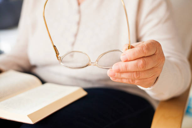 istock senior woman holding book 912501304