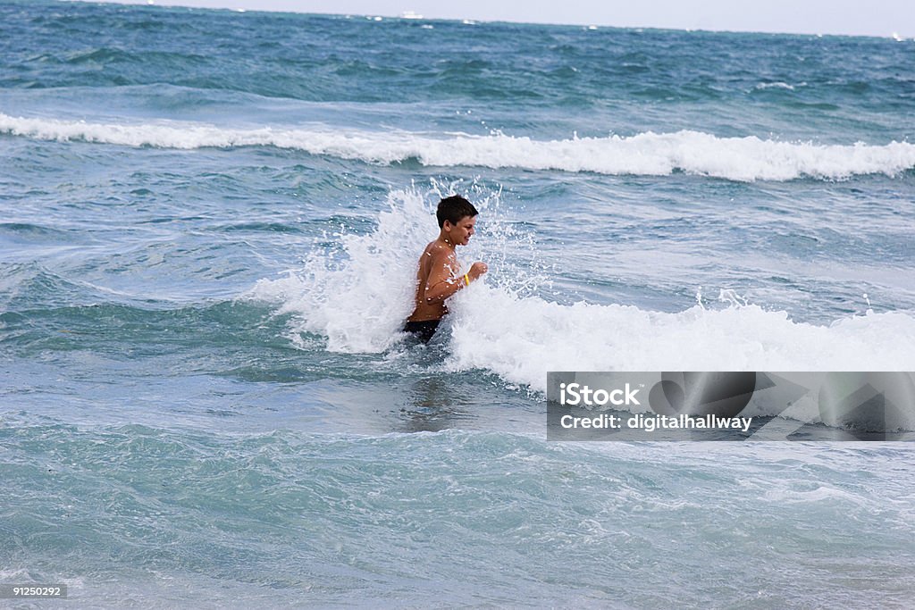 Petit garçon à l'eau à la plage - Photo de Adolescent libre de droits