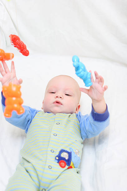 the baby is lying on a blue Mat at home among the toys, the concept of development and games