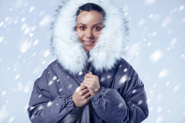istock Beautiful charming hispanic girl in blue coat with falling snow 912505632