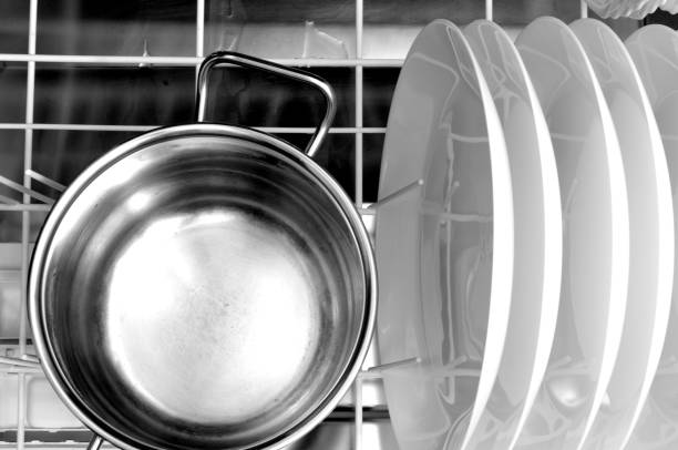 clean dishes and a steel pot in the dishwasher stock photo