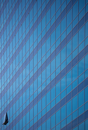 Glass wall of modern skyscraper with reflection, abstract background with copy space, full frame horizontal composition