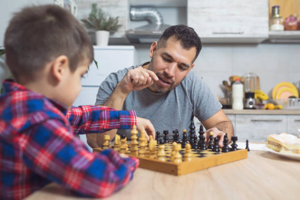 istock Father And Son Play Chess Together 912510098