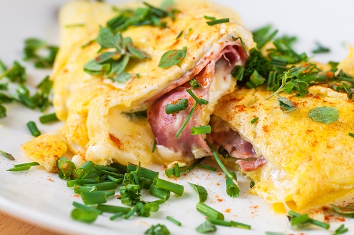 Egg omelette with ham and cheese with chive, closeup.