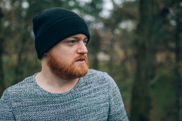istock young Redhead  bearded in a sweater  and cap, outside 912514616