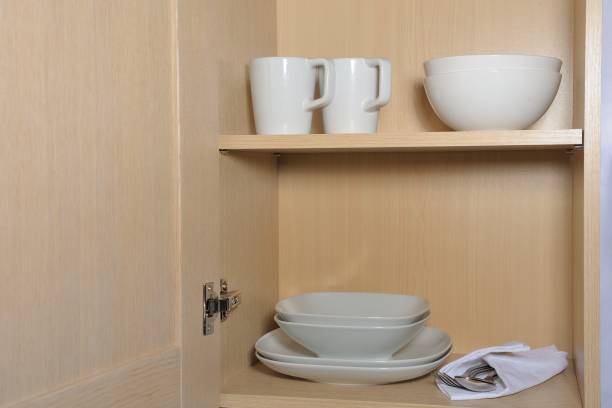different white dishes in cupboard in the kitchen - two objects cup saucer isolated imagens e fotografias de stock