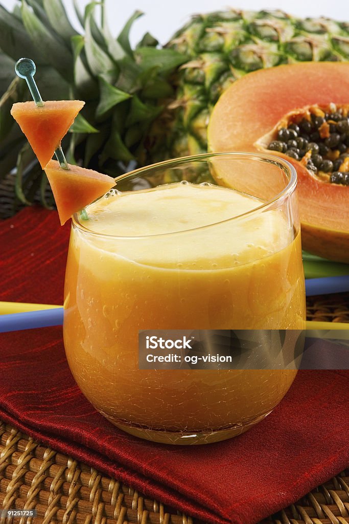 A tropical smoothie on a red napkin Papaya pineapple smoothie Papaya Stock Photo