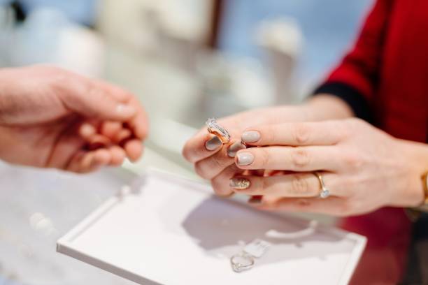weibliche verkäufer in einem luxus-schmuck-shop präsentiert einen ring. - jewelry shopping store diamond stock-fotos und bilder