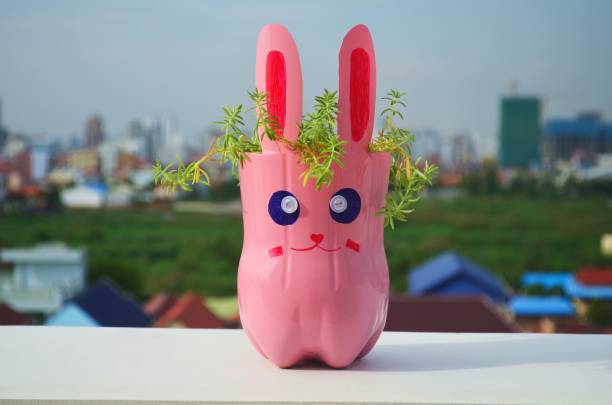 istock Pink rabbit as a funny flowerpot. 912525318