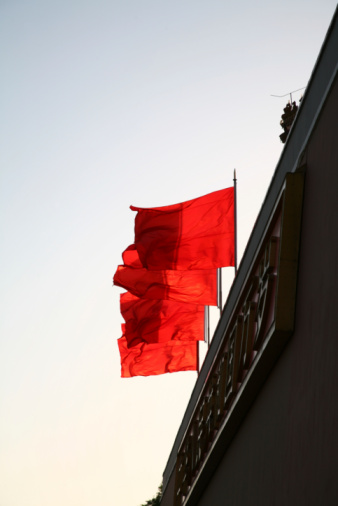 Flag of Spain with red and yellow colors waving in the wind during a sunny day with blue sky on summer