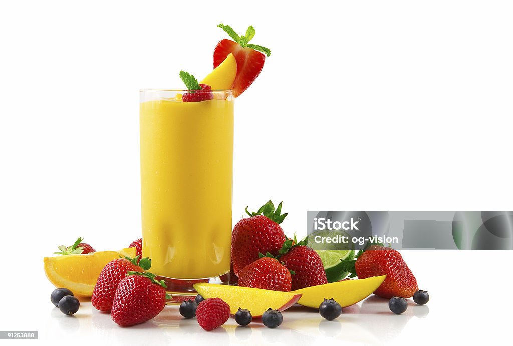 Glass of mango smoothie and fruits on a white background A glass of mango smoothie  surrounded by fresh fruits  Mango Fruit Stock Photo