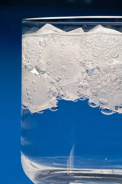 Floating ice cubes in water drink vertical stock photo