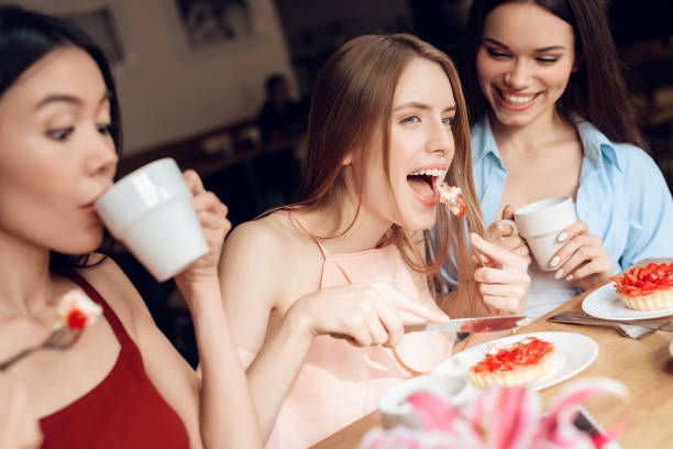 istock Three girls are sitting together in a cafe. 912542950