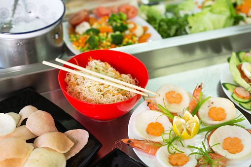 Presentation of nudles and salad in restaurant.