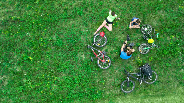 radfahren auf fahrräder im freien blick von oben, glückliche aktive eltern mit kind familie spaß und entspannung auf rasen, familie sport und fitness am wochenende - bike park stock-fotos und bilder