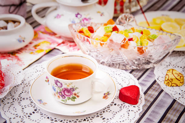 Steel-life with porcelain cup of tea, lemon slices and sweets