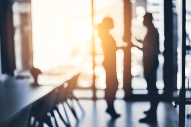 Defocused shot of two businesspeople having a discussion in an office