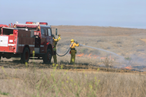 A firefighter watches a blazing wildfire.