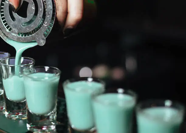 Photo of Alcohol bar, cocktail glass on bar counter, cocktail glass in a bar, Drinking cocktail in bar, cocktail in the glass with straws, Fresh drink coctail on a color background