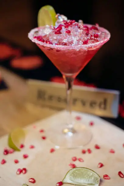 Photo of Alcohol bar, cocktail glass on bar counter, cocktail glass in a bar, Drinking cocktail in bar, cocktail in the glass with straws, Fresh drink coctail on a color background