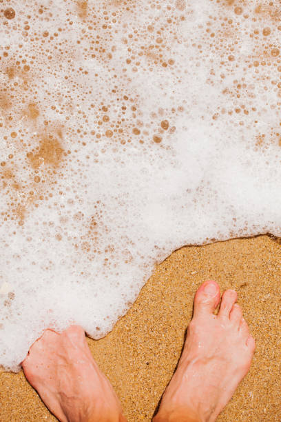 istock Tropical beach - feet in sand 912561458