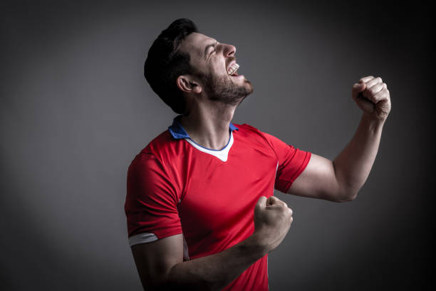 istock Fan / Sport Player on red uniform celebrating 912561682