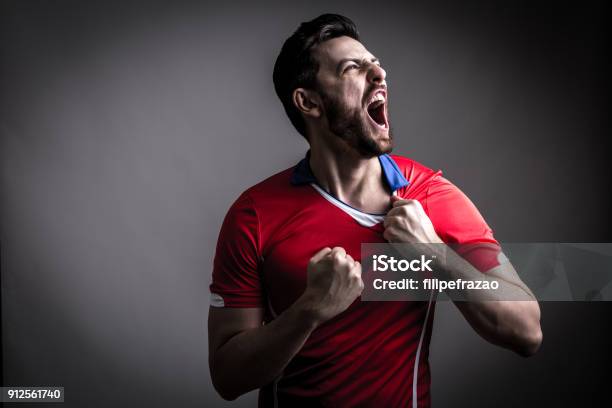 Photo libre de droit de Ventilateur Lecteur De Sport Sur Luniforme Rouge Célébrant banque d'images et plus d'images libres de droit de Football