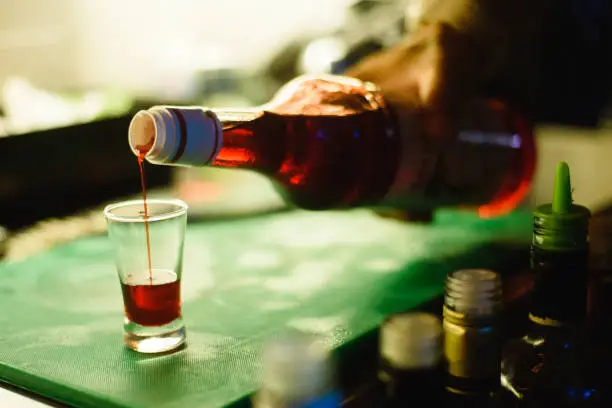 Photo of Alcohol bar, cocktail glass on bar counter, cocktail glass in a bar, Drinking cocktail in bar, cocktail in the glass with straws, Fresh drink coctail on a color background