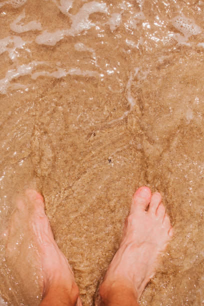 istock Tropical beach - feet in sand 912570156