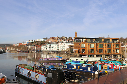 Picturesque scene taken at the Harbourside, Bristol featuring canal boats and modern apartments.