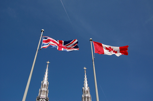 Looking east from Charing Cross, rows of British flag bunting strung between buildings on major thoroughfare linking Westminster and London.