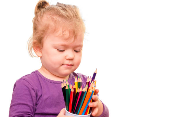 niña con lápices de colores en las manos, aisladas sobre fondo blanco - schoolgirl little girls crayon human face fotografías e imágenes de stock
