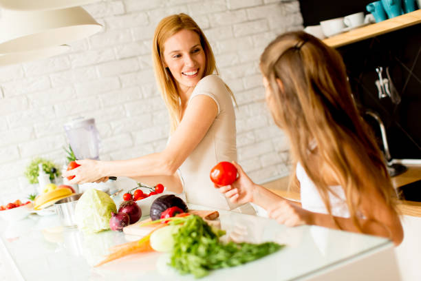 istock Mother and daughter in the modern kitchen prepating food 912574802