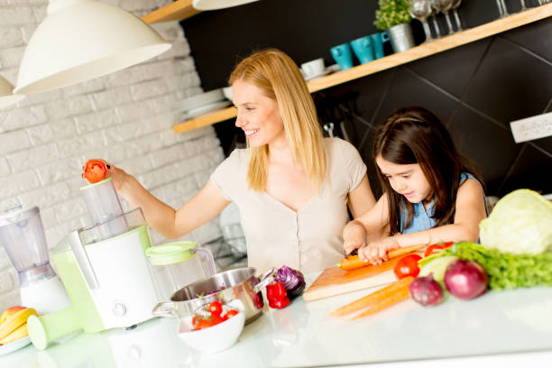 istock Mother and daughter preparing healthy juice 912574900