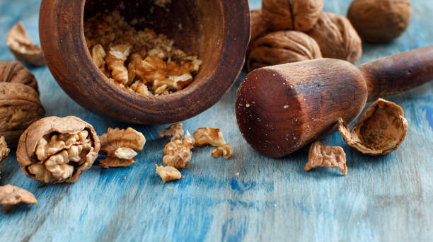 istock Fresh walnuts and mortar on a blue wooden table 912575008