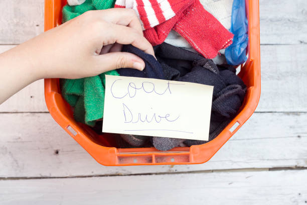 istock woman giving a orange clothes box for donation 912575786