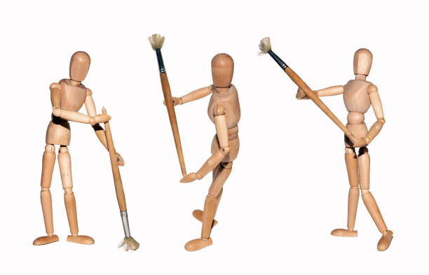 istock Painter's wooden models holding paintbrushe in different poses isolated on white 912582380