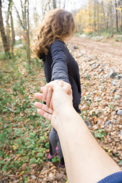 Two hikers in nature. Close Up of man and woman holding hands while walking pathway
