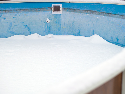 Outdoor swimming pool covered with ice and snow